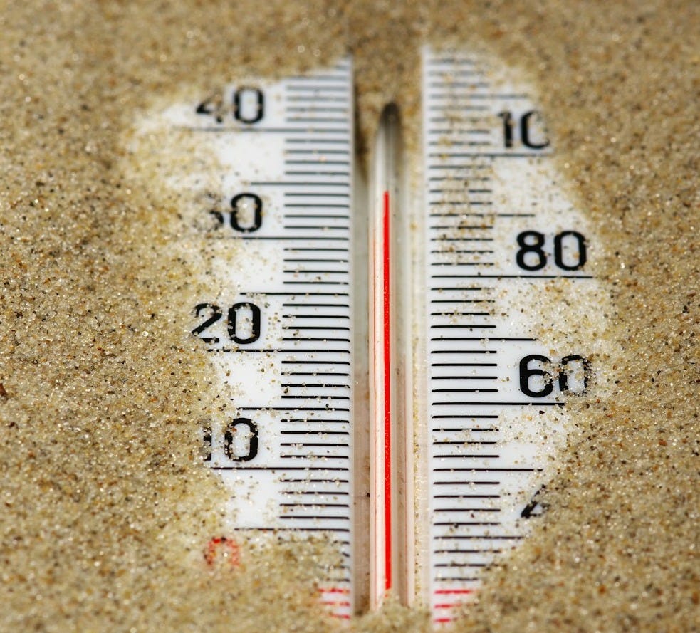 a close up of a thermometer in the sand a close up of a thermometer in the sand