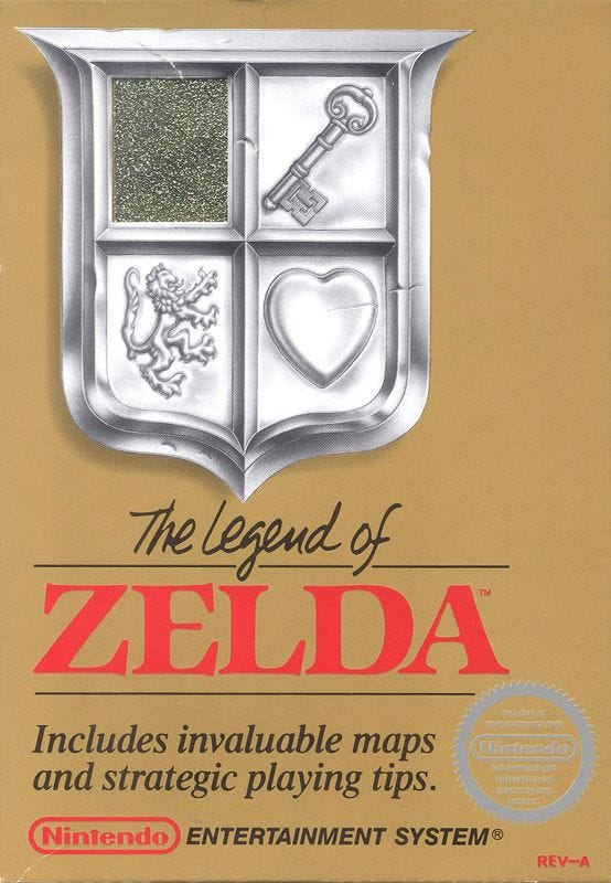 An image of The Legend of Zelda's North American box art, which does not include Link, but instead a shield with a heart, key, and more shown on its face, as well as the game's logo and promises of "invaluable" maps and tips contained within.