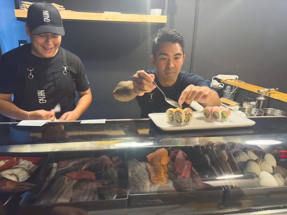 Two chefs at Gaijin enjoying themselves as they put the finishing touches on maki rolls.