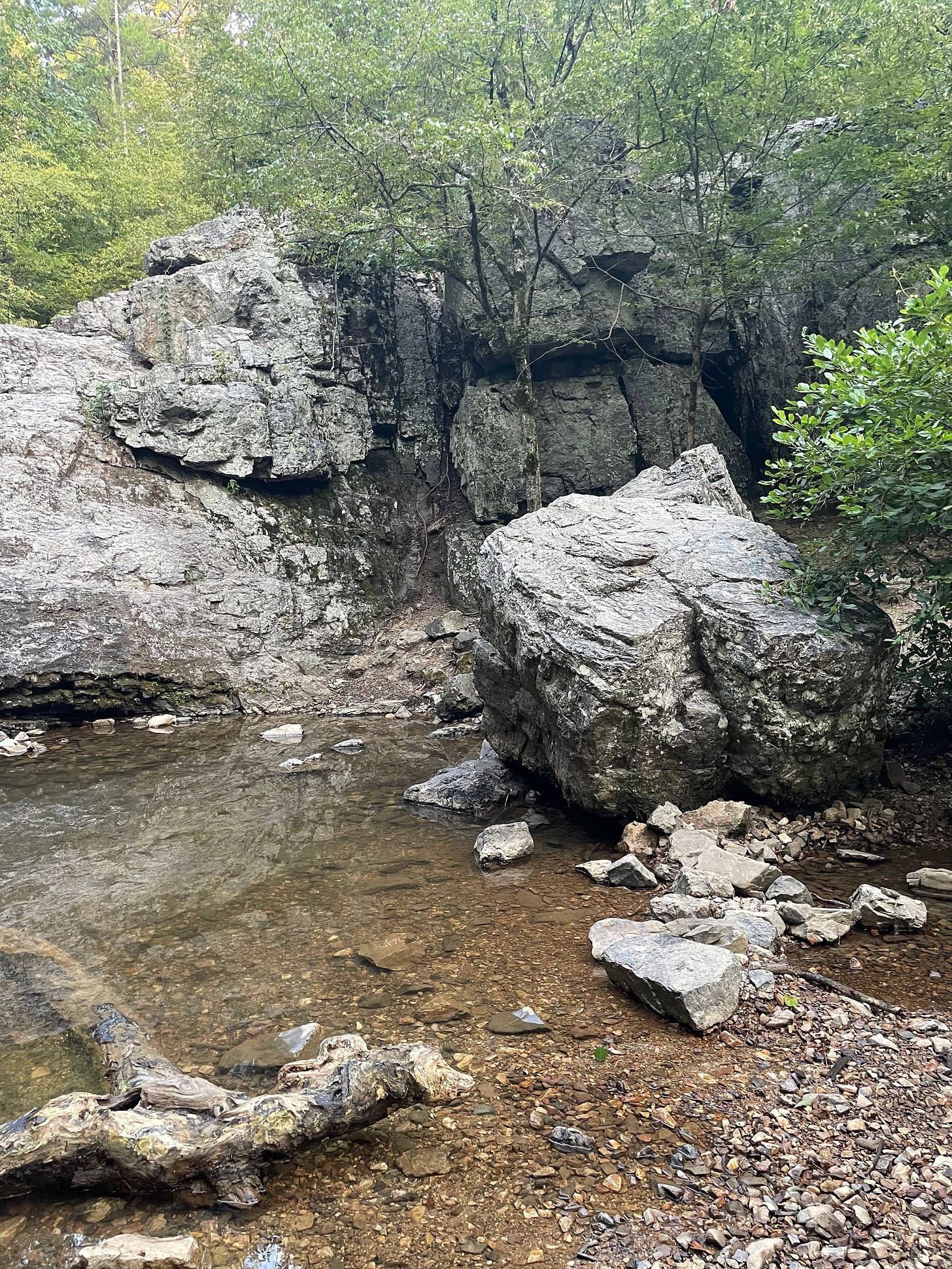 small rocky cliff where a waterfall used to be with a small body of water beneath it