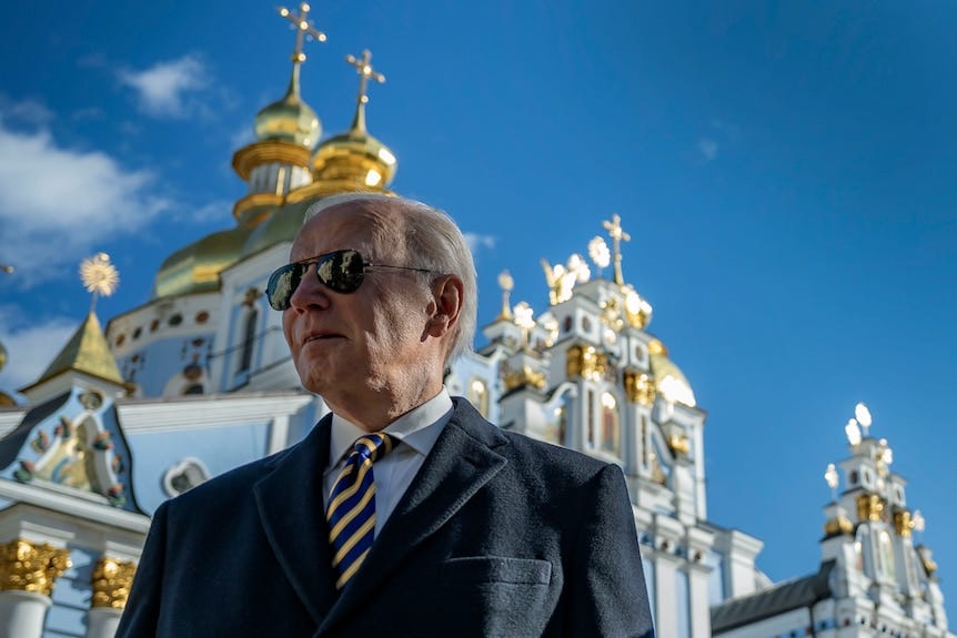 Joe Piden stands outside a white and gold cathedral wearing sunglasses. 