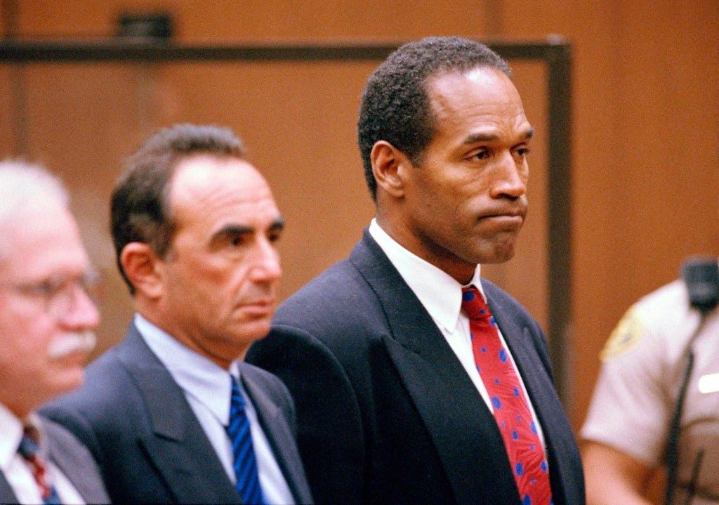 O.J. Simpson standing in court listening to Judge Kathleen Kennedy-Powell's decision, with lawyer Robert Shapiro in 1994