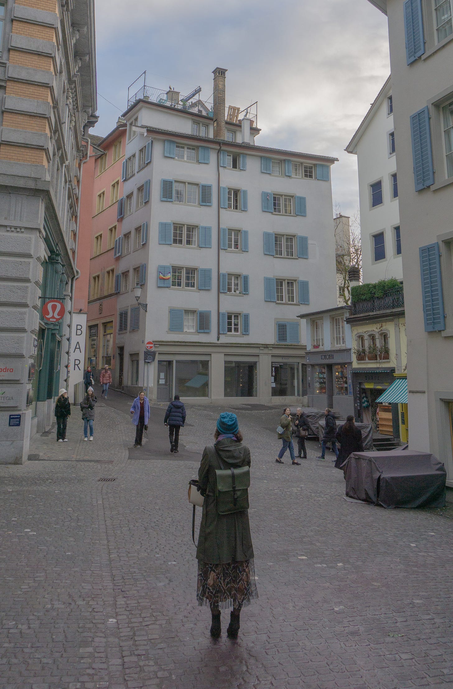 A woman in green in front of a tall building