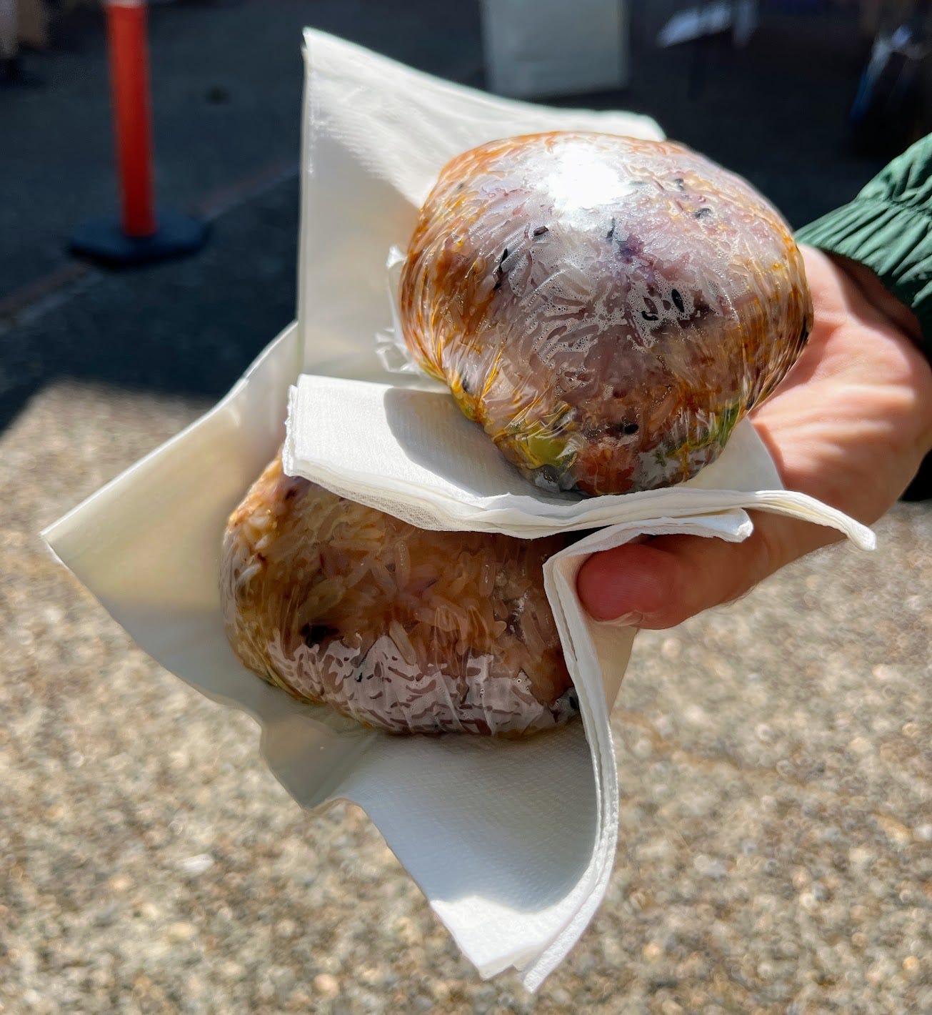 Hand holding two sticky rice balls