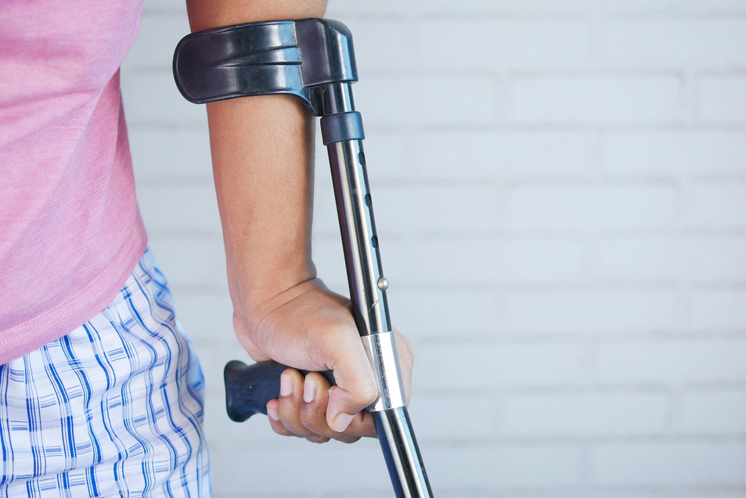 part view of person walking with an elbow crutch demonstrating fracture