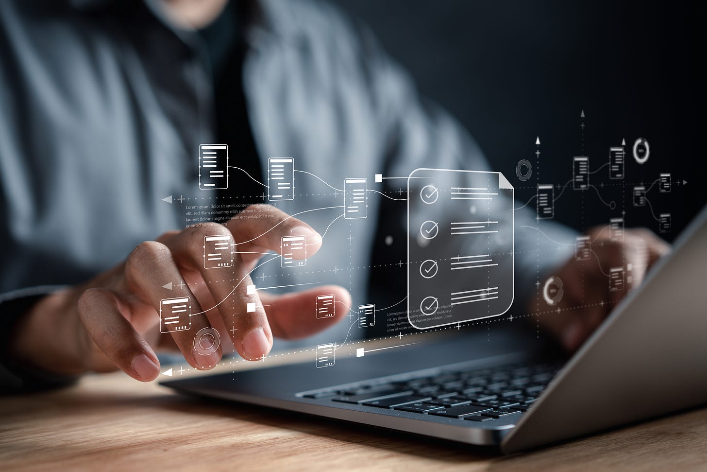 Closeup of a businessman's hands manipulating superimposed images of documents above his laptop keyboard.