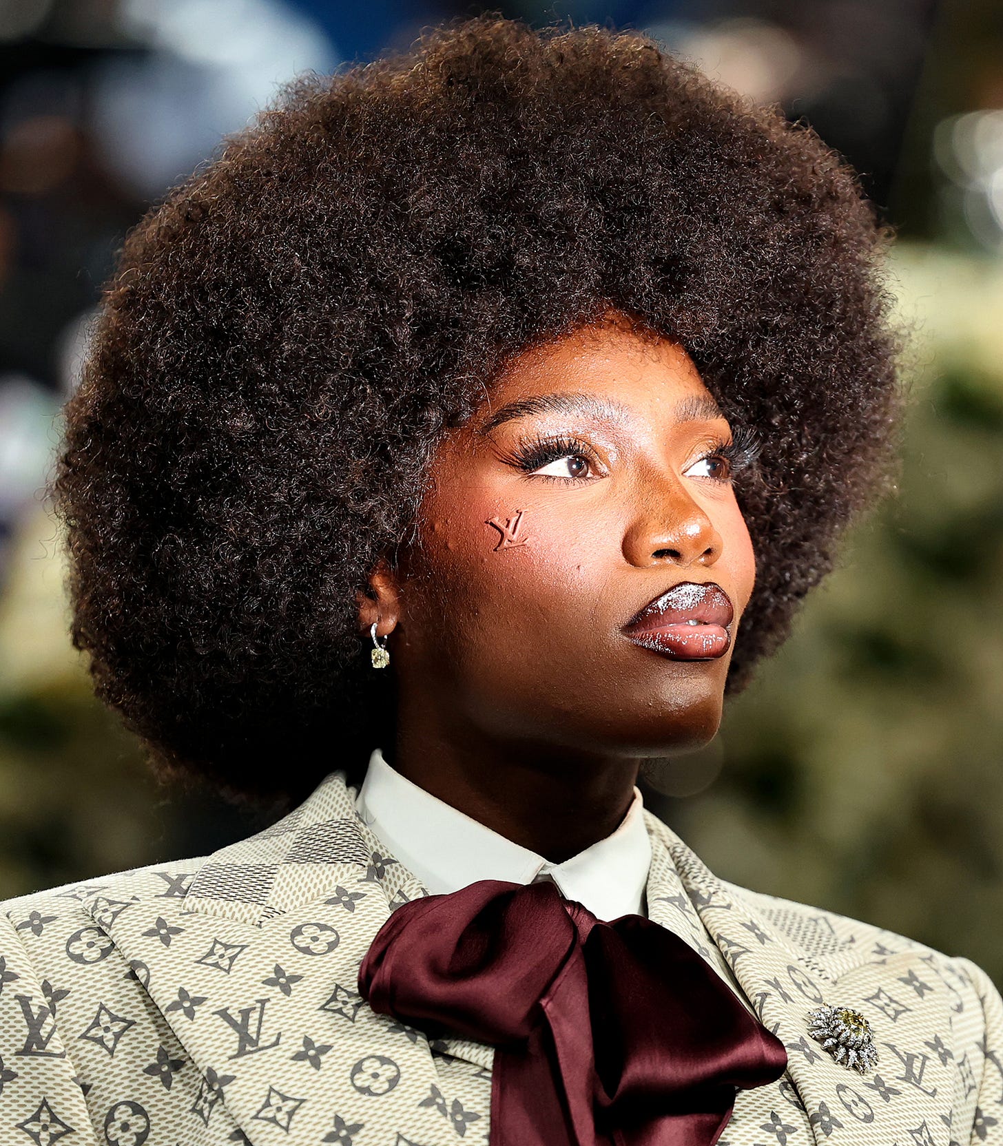 Doechii at the 2025 Met Gala with the Louis Vuitton logo on her face
