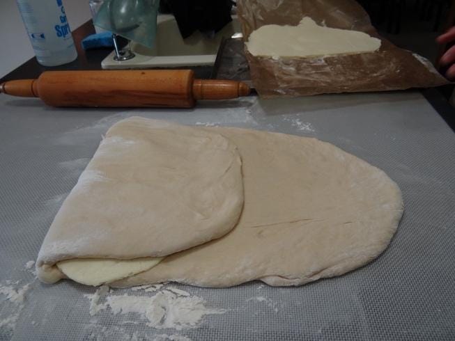 A dough with a rolling pin on a table

Description automatically generated