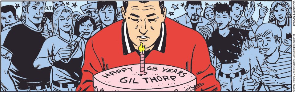 Gil Thorp blows out a candle on his birthday cake that reads "Happy 65 Years Gil Thorp" while he is surrounded by his friends and family