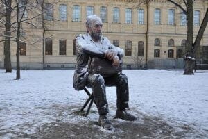 Man sitting in a chair outside in the cold snow