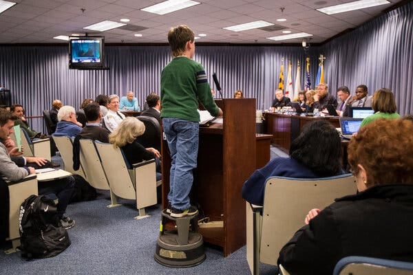 A young boy stands on a step stool to address the City Council in Hyattsville, Md.