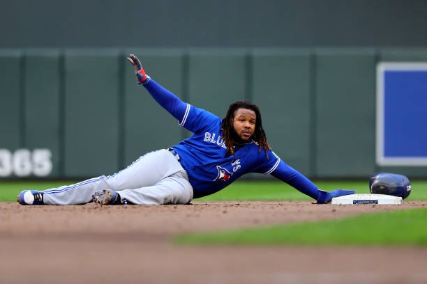 Vladimir Guerrero Jr. #27 of the Toronto Blue Jays reacts after being tagged out at second base against Carlos Correa of the Minnesota Twins during...