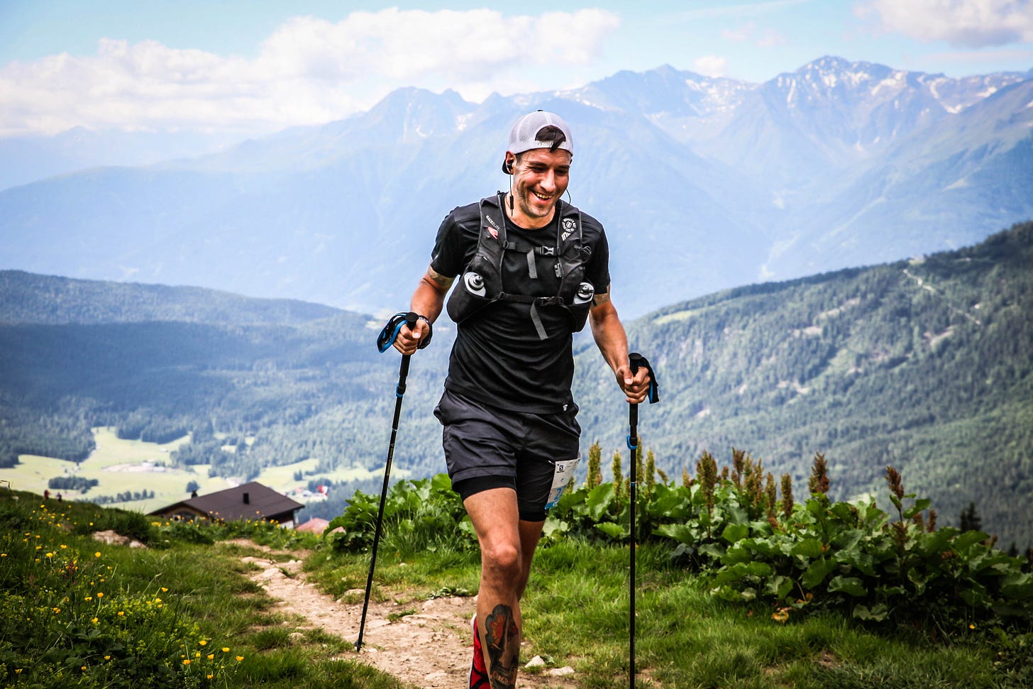 The author running mit poles up a mountain smiling