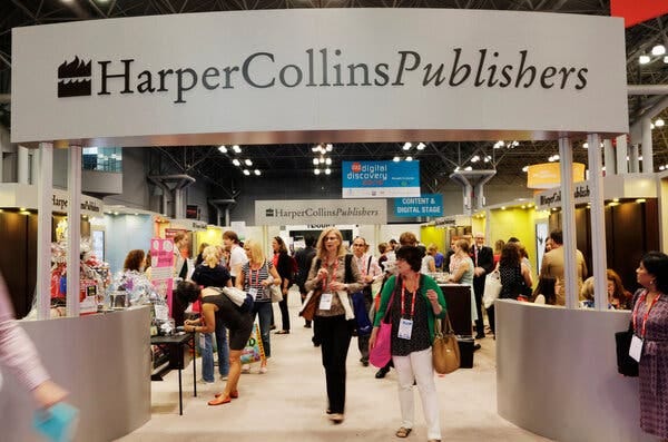 A large banner saying “HarperCollins Publishers” arches over a room full of people with badges around their necks. It is a photo taken at the HarperCollins booth at BookExpo America in 2015. 