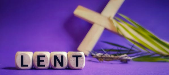 Lent is spelled out on wood blocks in the foreground, with a purple backdrop and palm cross behind it