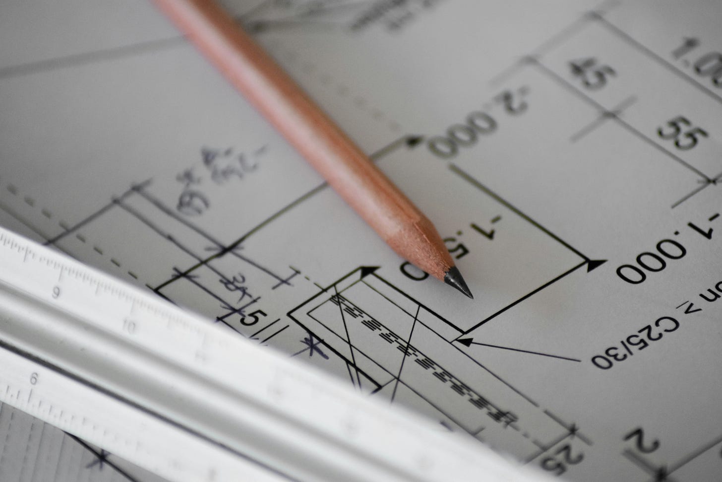 Image of pencil laying on top of drafting plans.