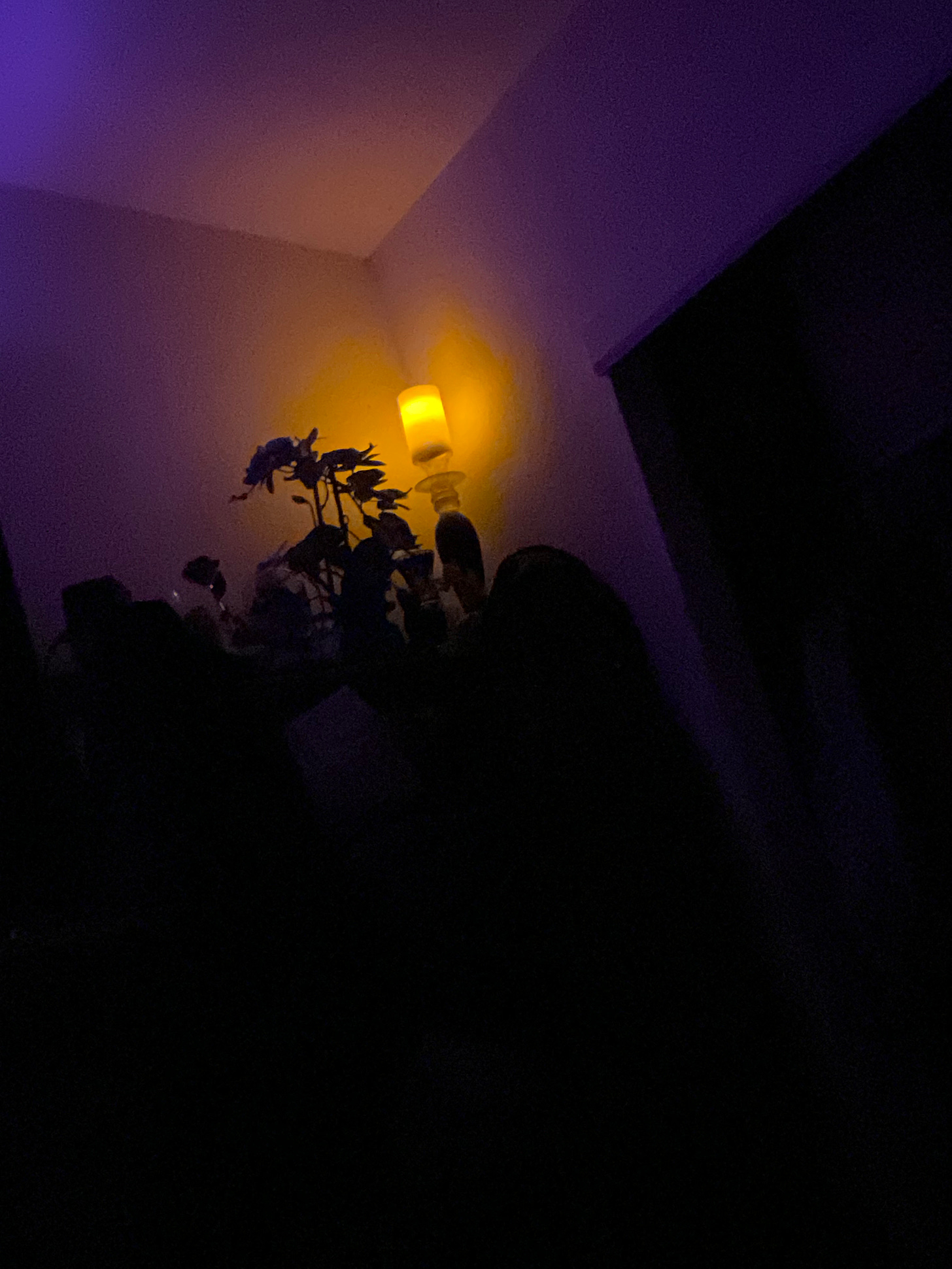 Picture of one electronic candle on in the corner of a dark room