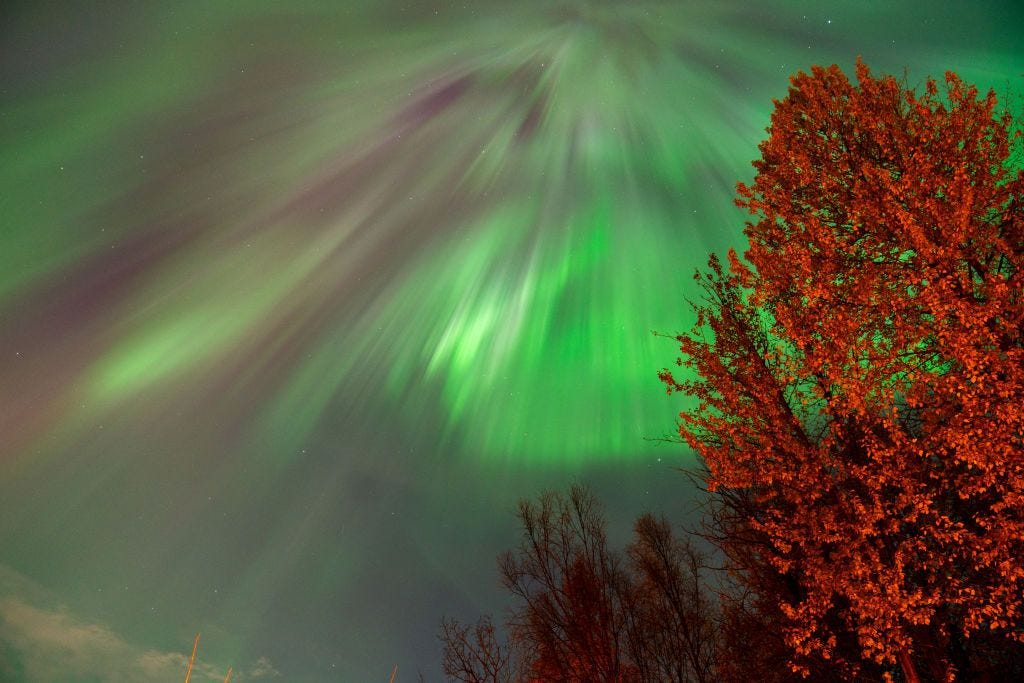 The Aurora Borealis are green streaks against the night sky.