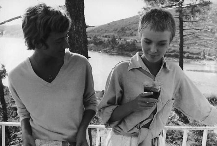 This may contain: two young boys standing next to each other on a balcony looking at their cell phones