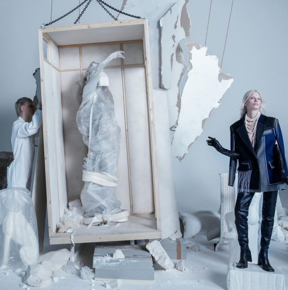 Model Kristen McMenamy is seen amid rubble and mannequins wrapped in a cloth that looks similar to the body bags used to hold the corpses of dead Palestinians.