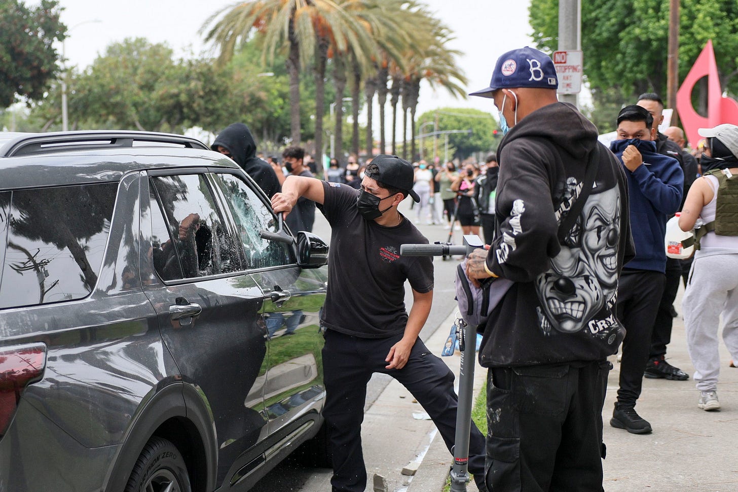 Protesters smashing open a car Protesters smashing open a car