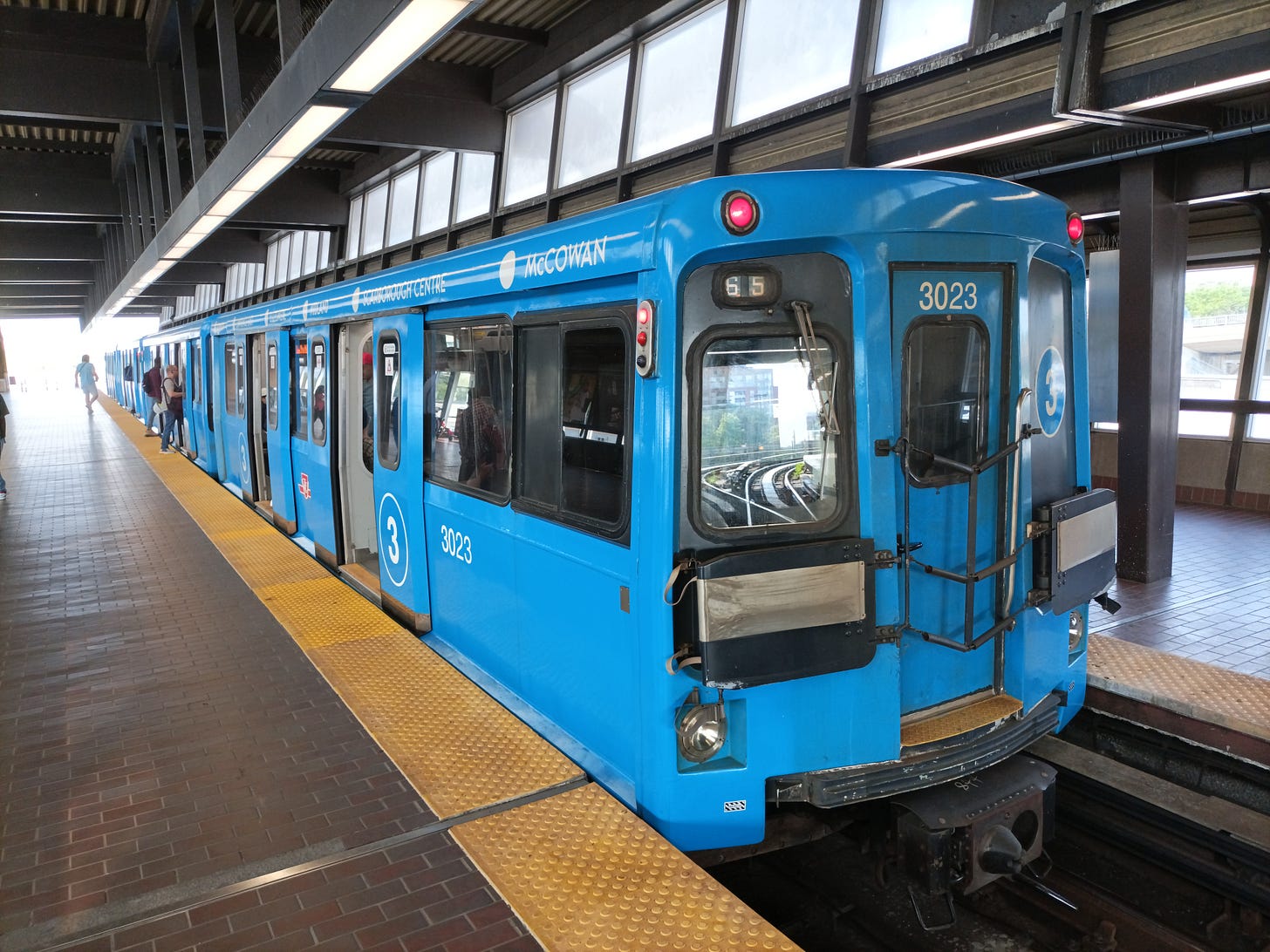 Line 3 Metro train in Toronto at Kennedy Station platform, waiting with doors open for passengers to board.