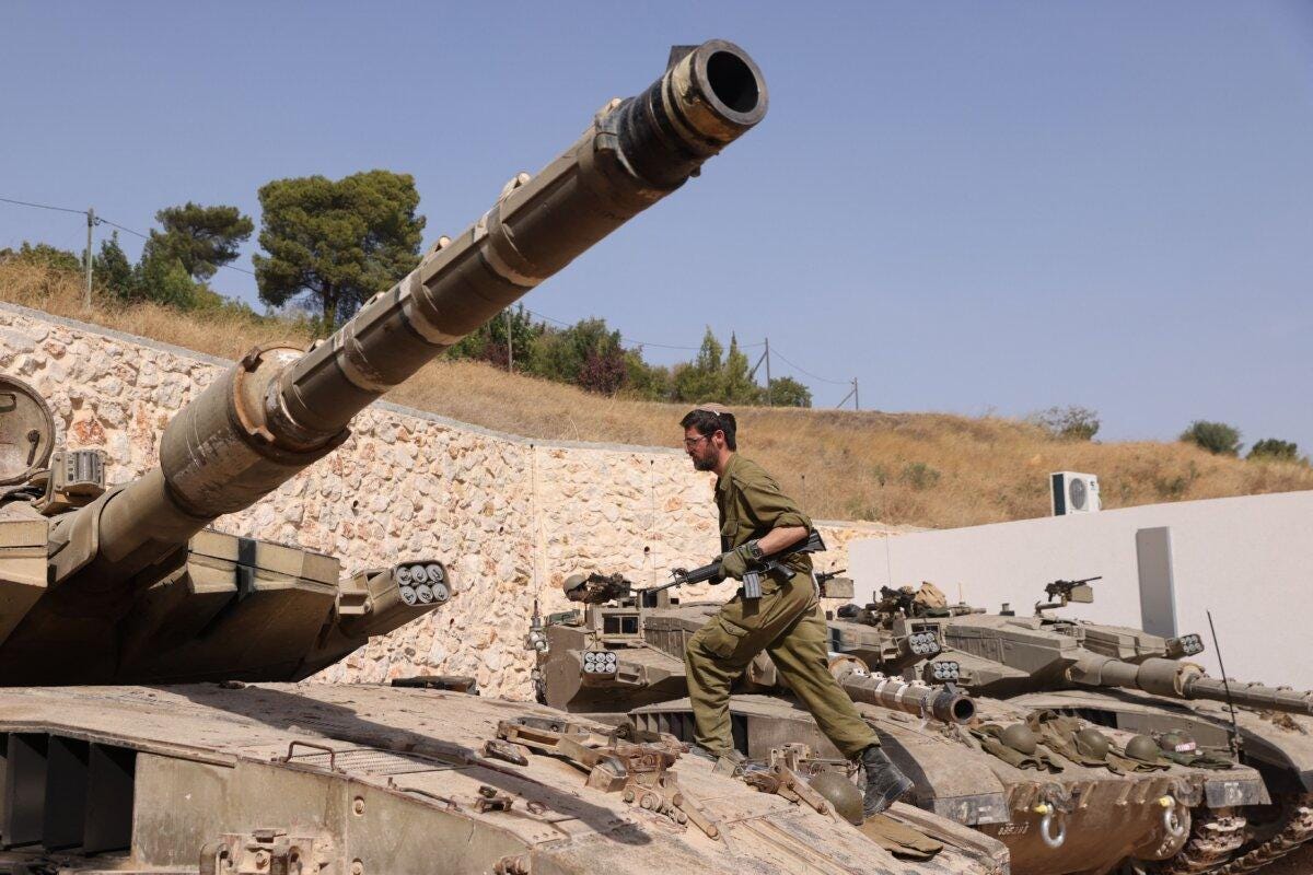 An Israeli soldier walks on a Merkava tank at a position in an undisclosed location on the border with Lebanon on Oct. 22, 2023. (Jalaa Marey/AFP via Getty Images)