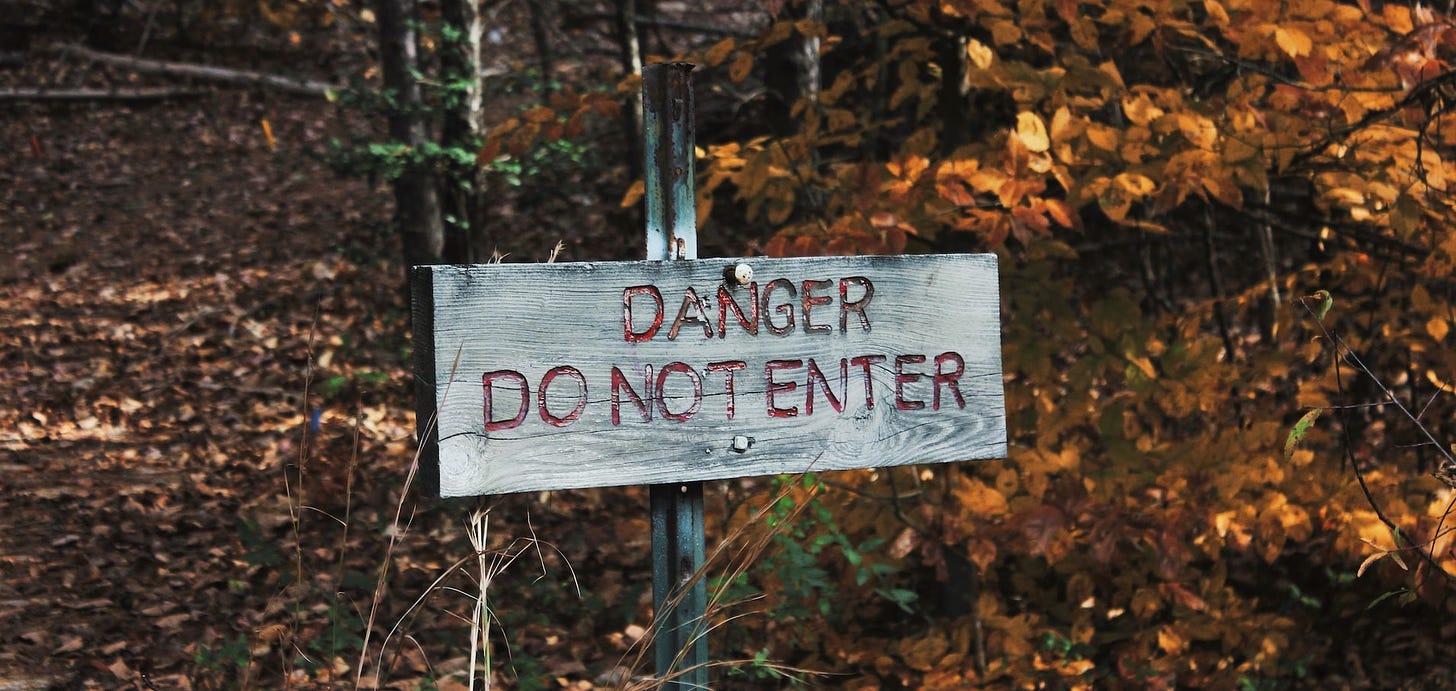 A sign saying Danger do not enter, posted in the woods