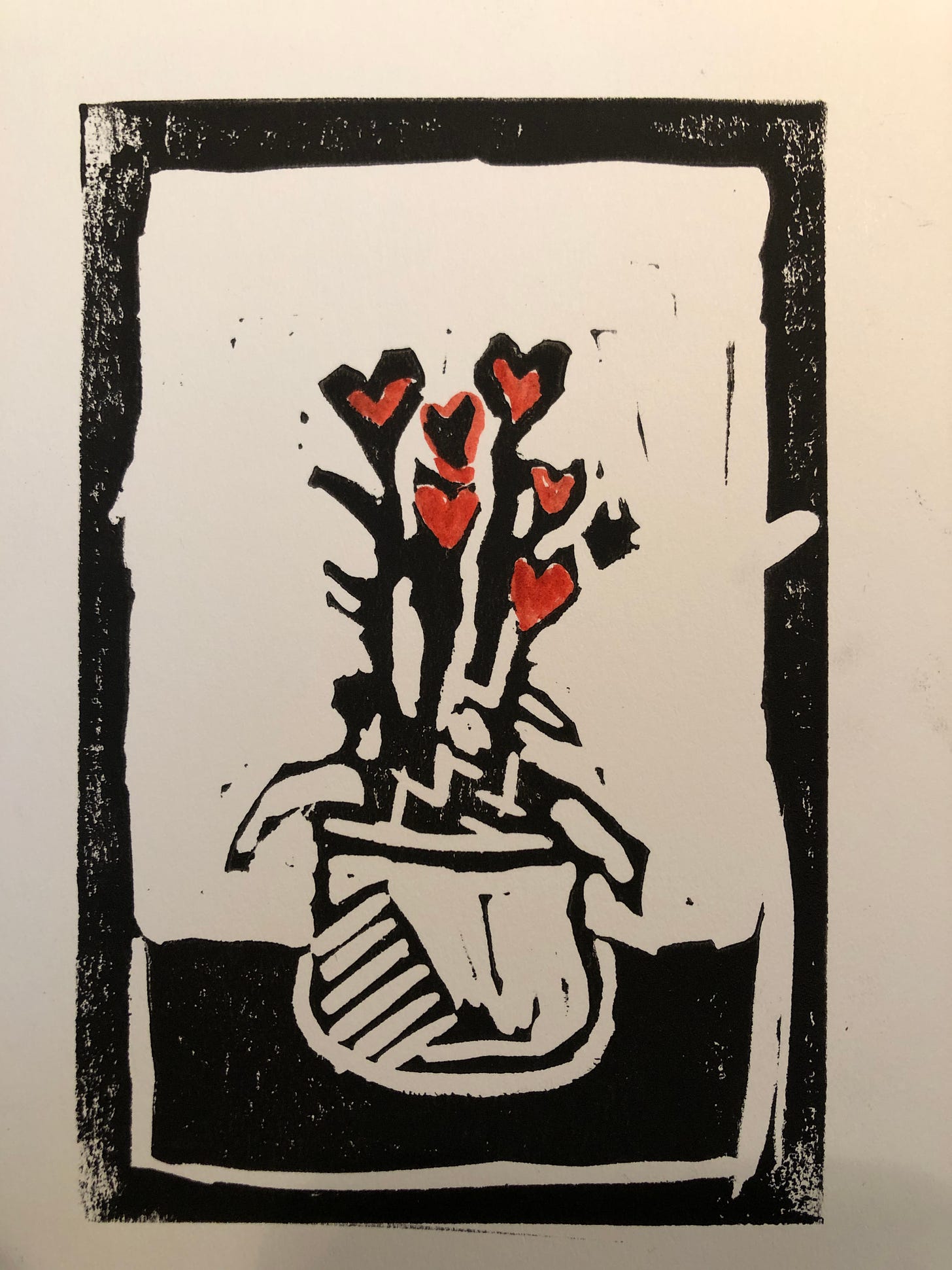A black and red stamp of a potted plant with hearts at the top of the plant.