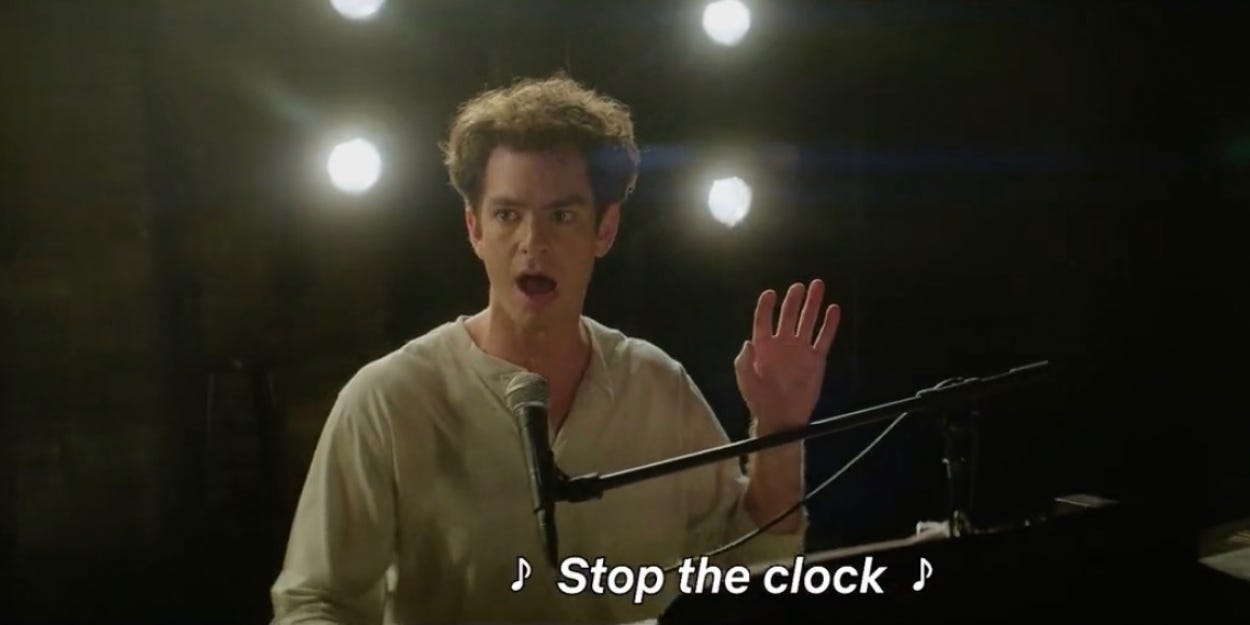 Imagem do Andrew Garfield em Tick Tick Boom, filme da Netflix, cantando e dizendo Parem os relógios!