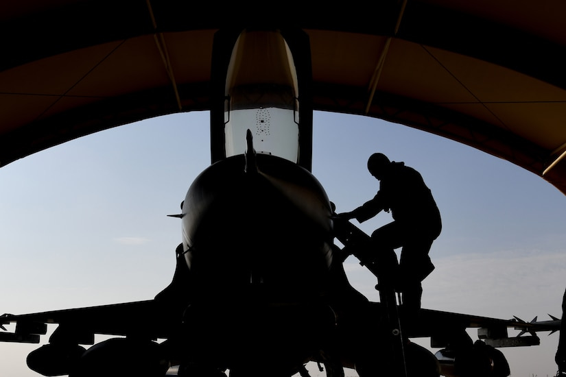 The silhouette of an airman climbing into an aircraft is shown.