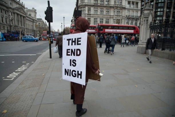 Demonstrator with a sandwich board reading The End Is Nigh protests in Westminster on Budget Day on 22nd November 2017 in London, England, United...