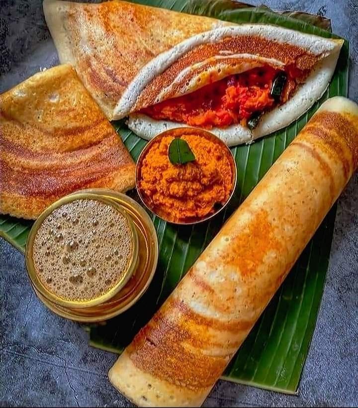 This may contain: some food is laying out on a banana leaf with sauces and condiments
