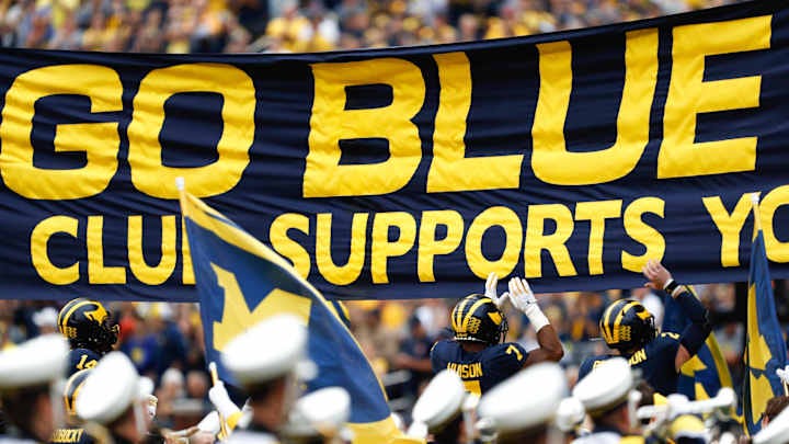 Sep 28, 2019; Ann Arbor, MI, USA; Michigan Wolverines linebacker Khaleke Hudson (7) and quarterback Shea Patterson (2) jump and touch the banner before the game against the Rutgers Scarlet Knights at Michigan Stadium. Mandatory Credit: Raj Mehta-Imagn Images