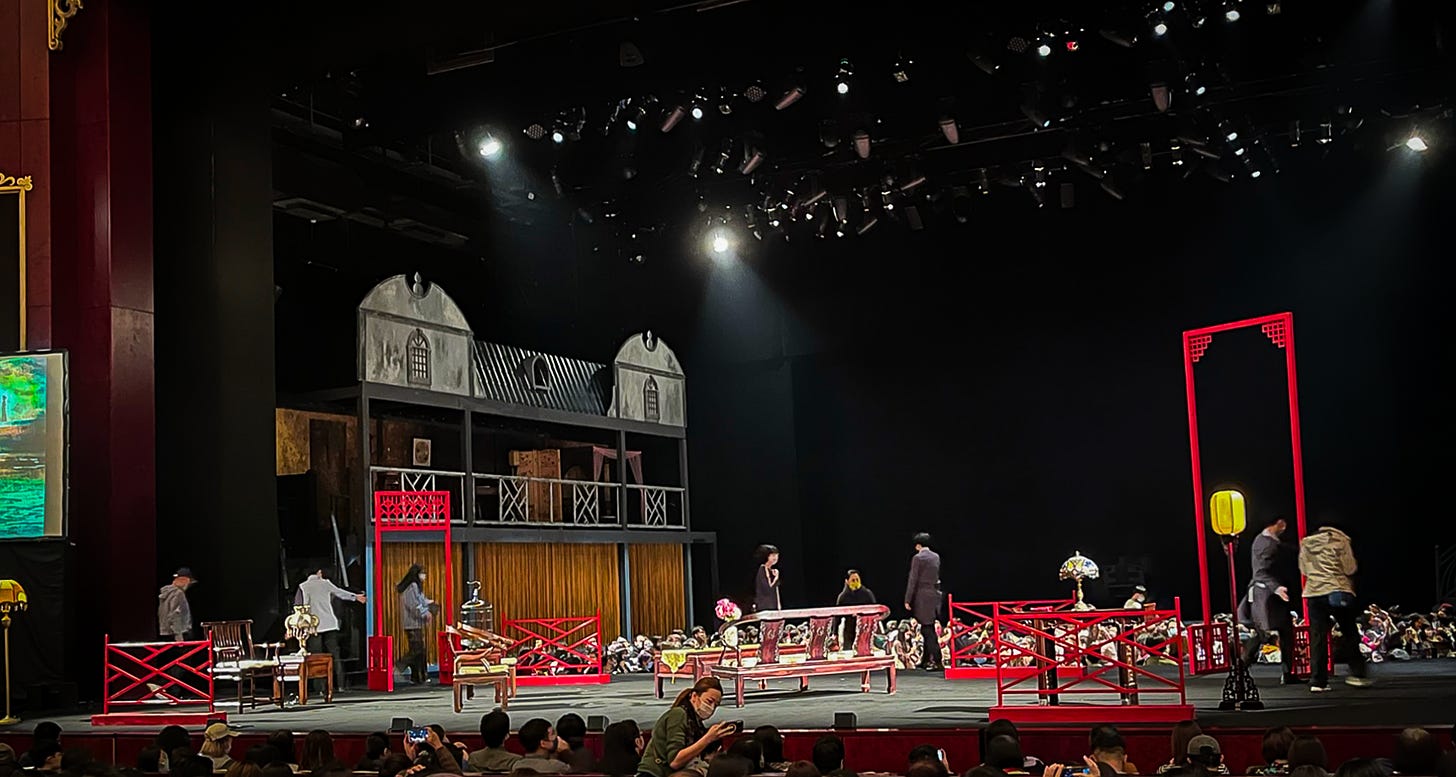 Red-framed wooden furniture represents the interior of a 1930s Shanghai brothel in the second act of "A Dream Like a Dream"