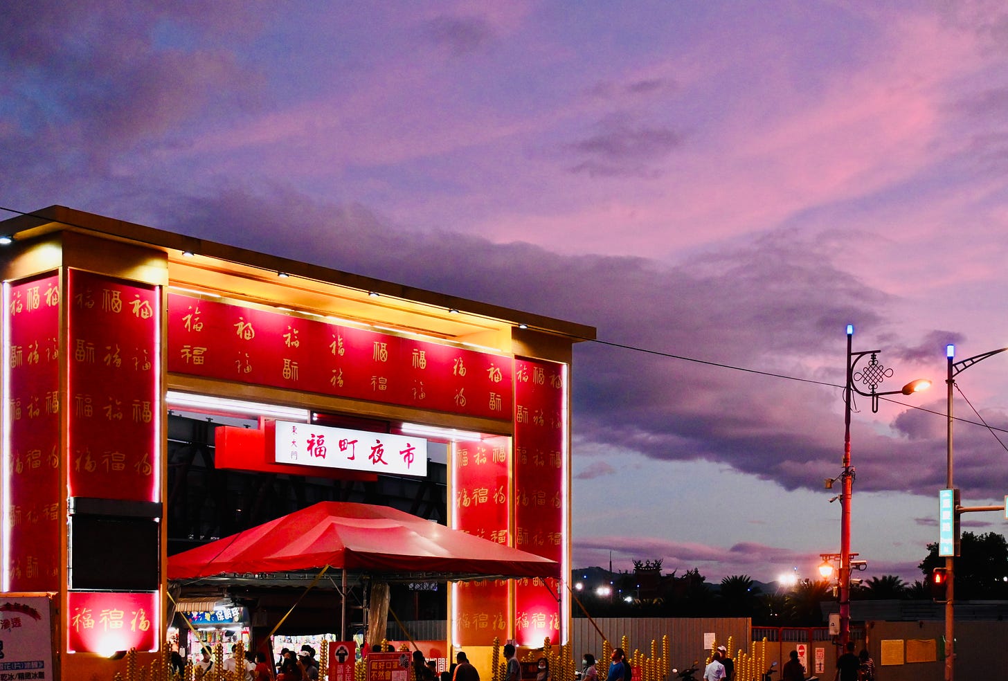 A spectacular sunset turns the clouds purple above the massive red gate to Dongdamen 東大門 night market in Hualien 花蓮, Taiwan