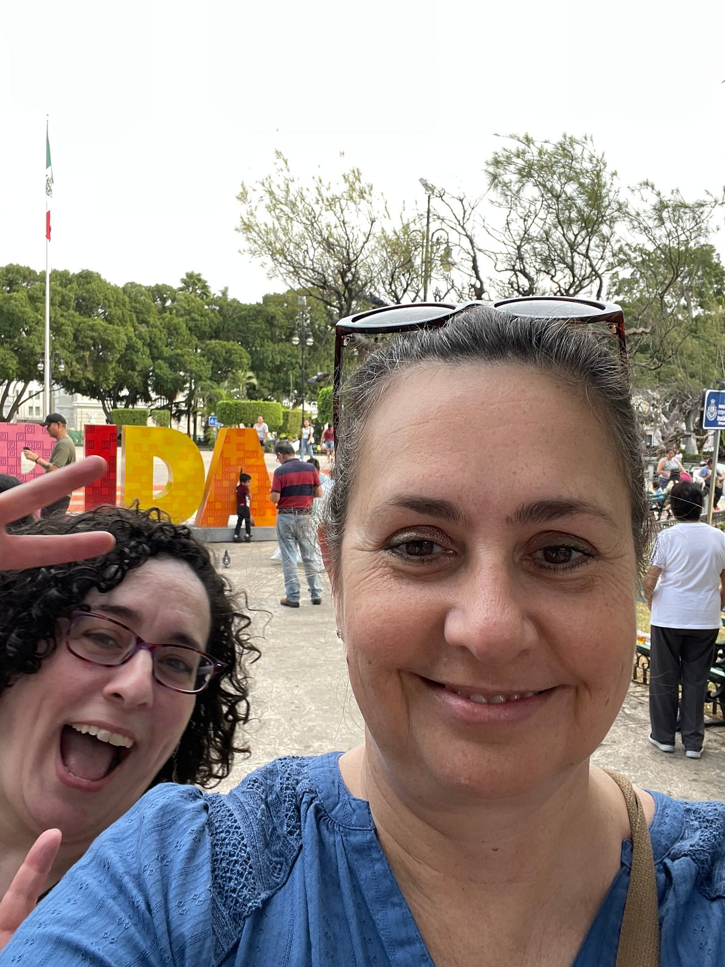 Posing for a selfie in front of the Merida sign at the city center, with photobomb by my friend Theresa.