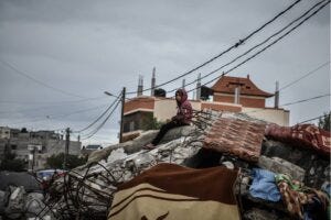 A child sits on top of a debris of a collapsed structure at the area where displaced Palestinian families who took refuge in Rafah, Gaza continue to live under difficult winter conditions in makeshift tents on January 28, 2024