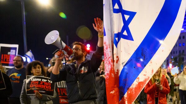 A protester with red paint on his hand marches through the streets after demonstrating outside the Israel Defense Forces headquarters on Dec. 15 in Tel Aviv, Israel.