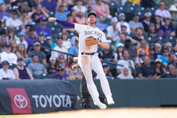 Ryan McMahon of the Colorado Rockies throws to first base during the tenth inning of a game against the Minnesota Twins at Coors Field on October 1,...