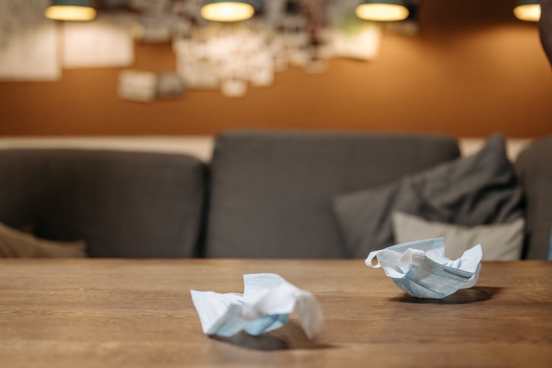 Free Close-up of unused face masks on a wooden table inside a cozy room. Stock Photo Free Close-up of unused face masks on a wooden table inside a cozy room. Stock Photo