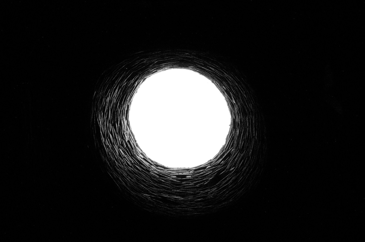 Looking up to the sky through a deep tunnel