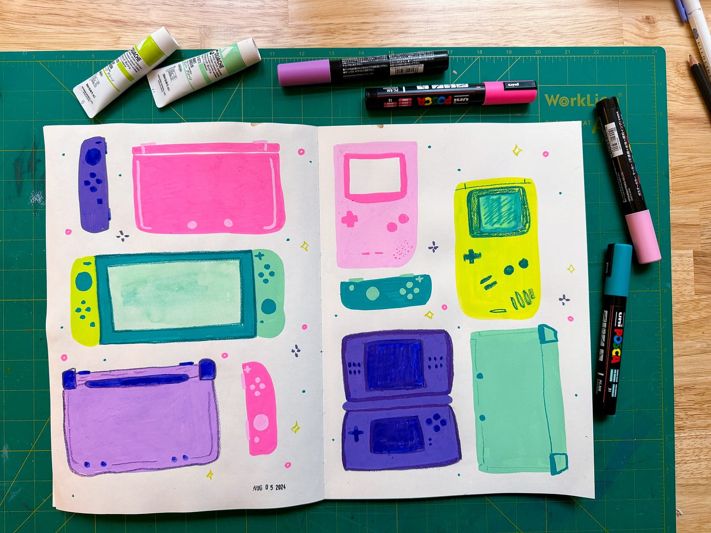 acrylic paintings in a sketchbook of various nintendo handheld gaming systems in bright colors