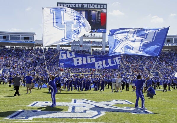 Kentucky players and cheerleaders take the field before an NCAA college football game against Louisville on Saturday, Sept. 14, 2013, in Lexington, Ky. (AP Photo/James Crisp, File)