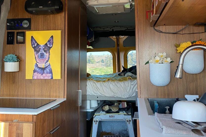 The interior of our converted camper van viewed from the front cab looking back towards the bed