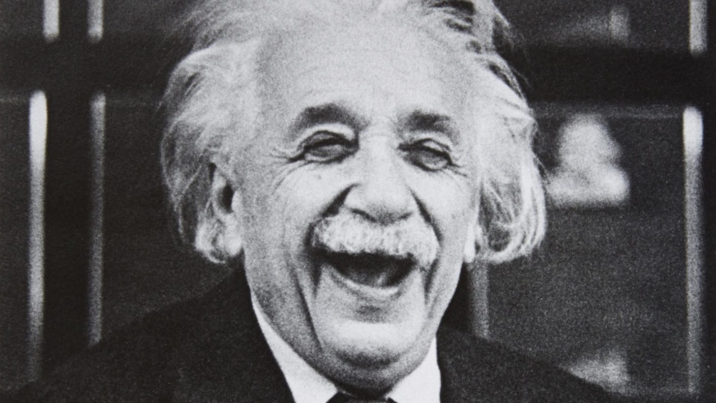 A black and white photo of albert einstein laughing. A black and white photo of albert einstein laughing.