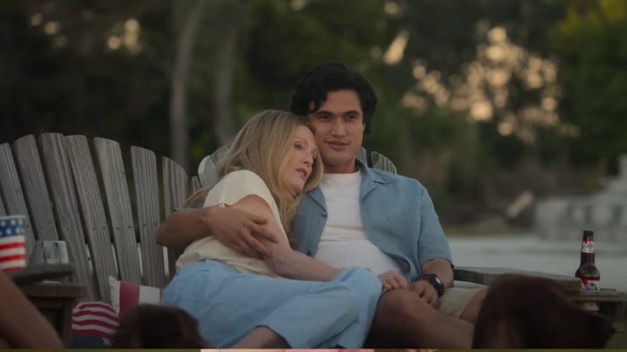 Actors Julianne Moore and Charles Melton sitting together on patio furniture together