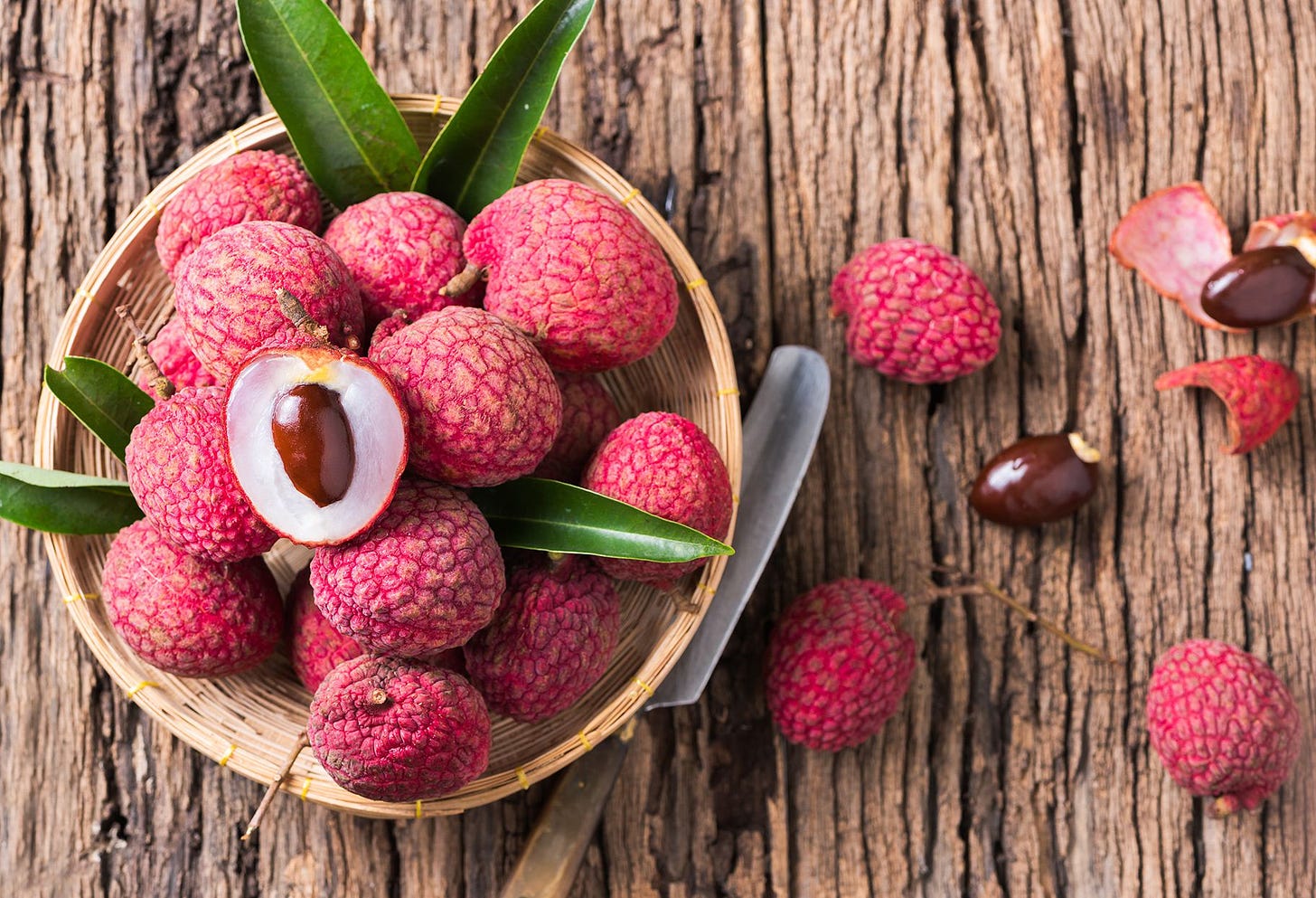 lychee in a bowl with one sliced open on top