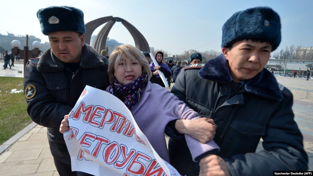 Kyrgyz police arrest a woman protesting against gender-based violence to mark International Women's Day in Bishkek in March 2020.