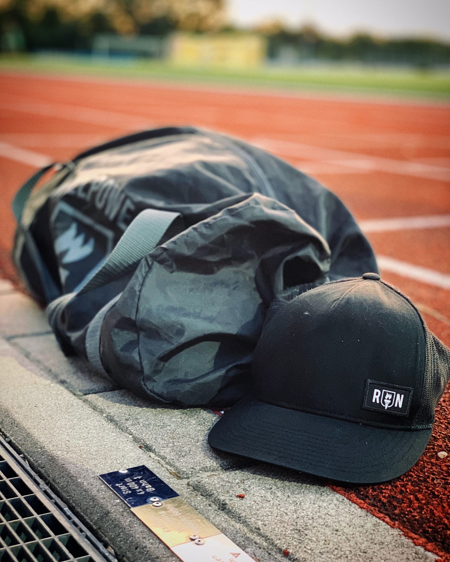 Willpower bag and cap on the side of a running track